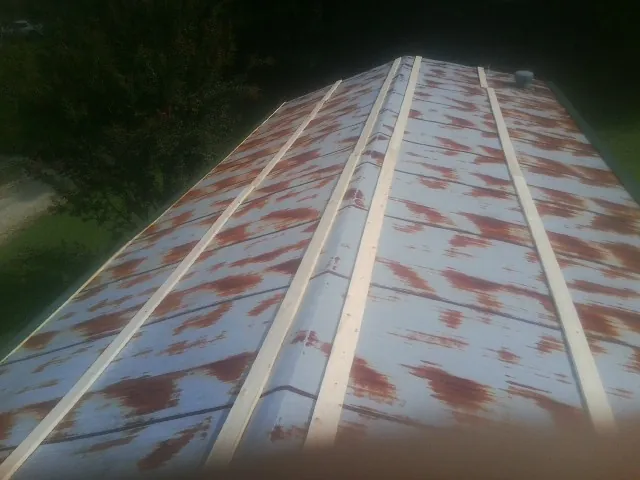 Rusted metal roof panels with new wood purlins before replacement — Storm Damage Roof Repair in Centereach by Roofing Brothers