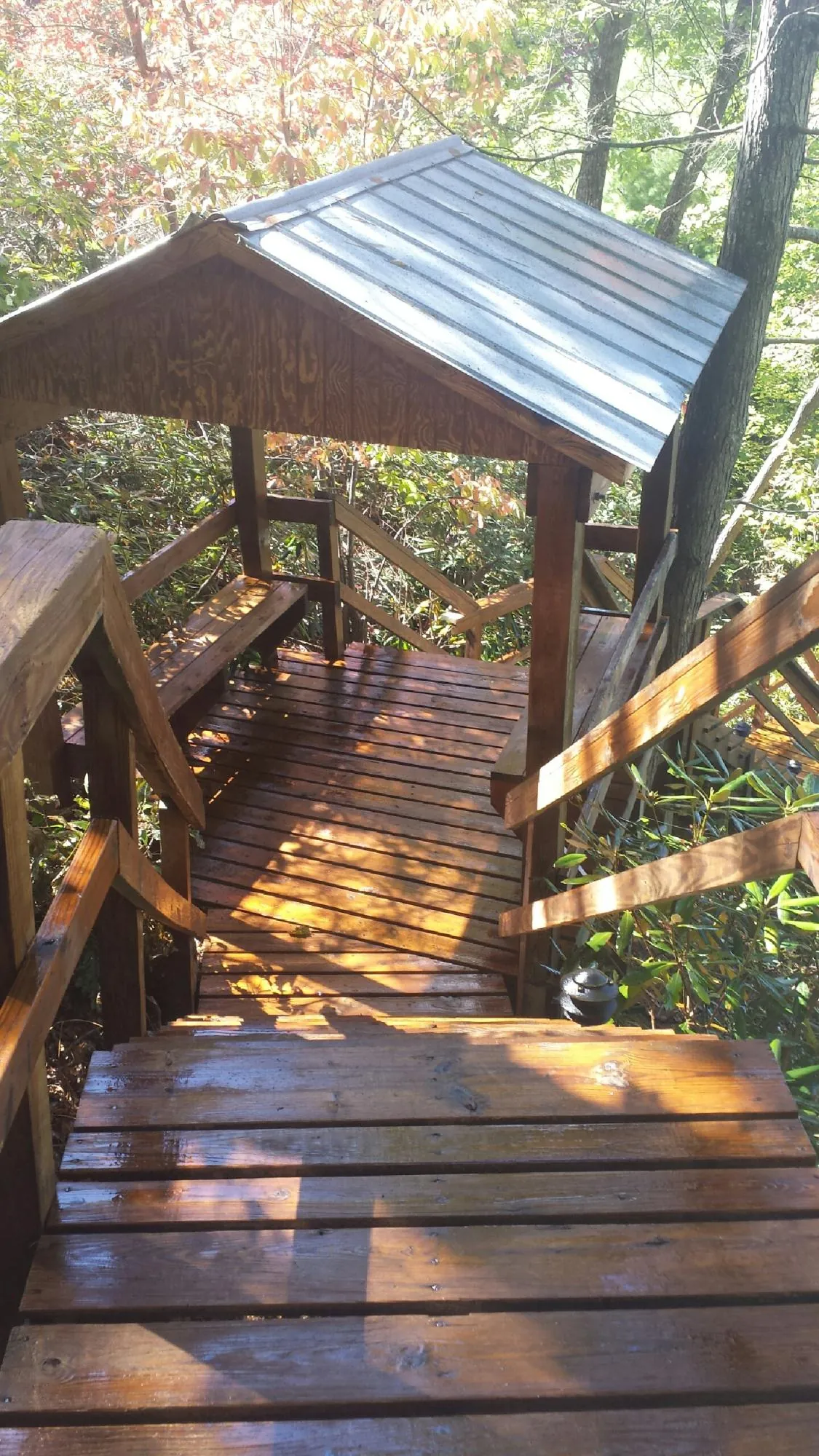 Freshly stained wood walkway and covered shelter with a metal roof in Centereach