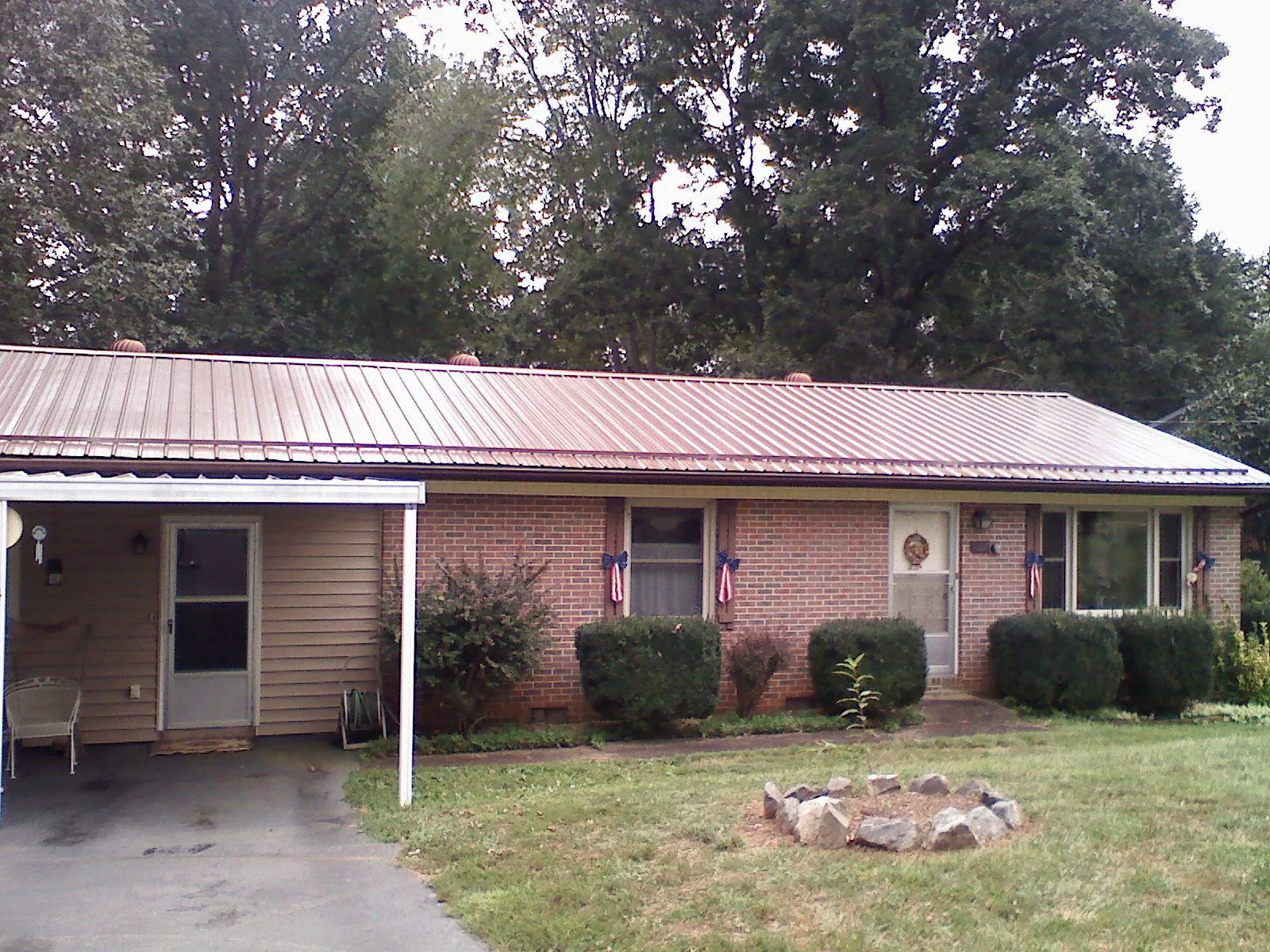 Bronze metal roof and carport on a brick ranch home — Roof Repair work by our crew in Centereach
